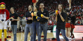 raiseRED volunteers toss out T-shirts at a basketball game in 2018-19.