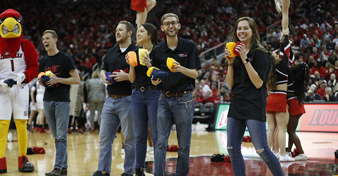 raiseRED volunteers toss out T-shirts at a basketball game in 2018-19.