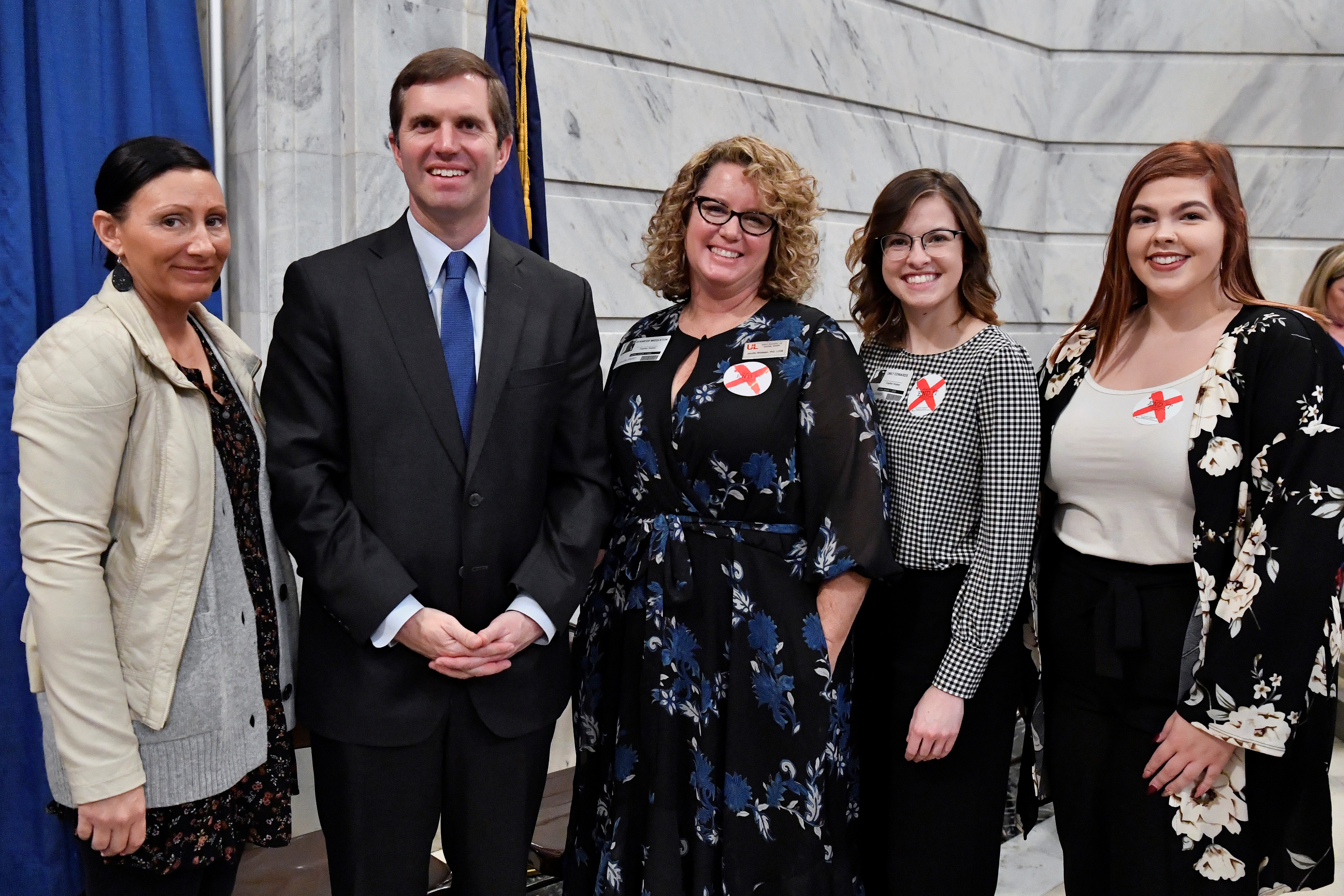 UofL researchers joined Gov. Andy Beshear at a Jan. 7 Capitol Rotunda news conference to raise human trafficking awareness. UofL graduate students Tara Sexton, Emily Edwards and Victoria Dobson are shown with Jennifer Middleton (center), associate professor of social work and director of the Human Trafficking Research Institute. Credit Timothy D. Easley.