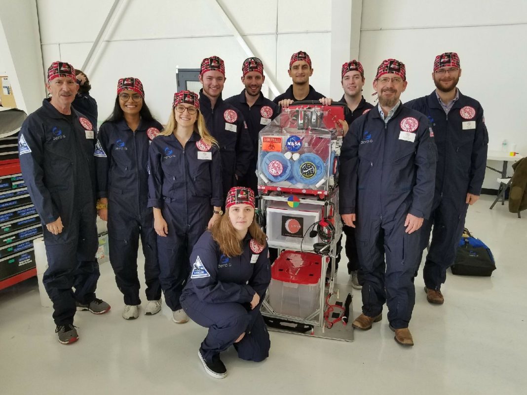 Research crew preparing to board ZERO-G aircraft with the glovebox. Left to right: George Pantalos, Ph.D., Riya Patel, Brooke Barrow, John Moore, Connor Centner, Charles Elder, David Grimm, Michael Menze, Ph.D., Brett Janis and Sienna Shacklette (kneeling).