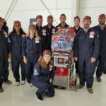 Research crew preparing to board ZERO-G aircraft with the glovebox. Left to right: George Pantalos, Ph.D., Riya Patel, Brooke Barrow, John Moore, Connor Centner, Charles Elder, David Grimm, Michael Menze, Ph.D., Brett Janis and Sienna Shacklette (kneeling).