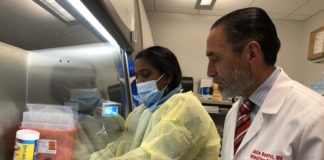 Julio Ramirez, M.D., right, in the UofL infectious diseases laboratory