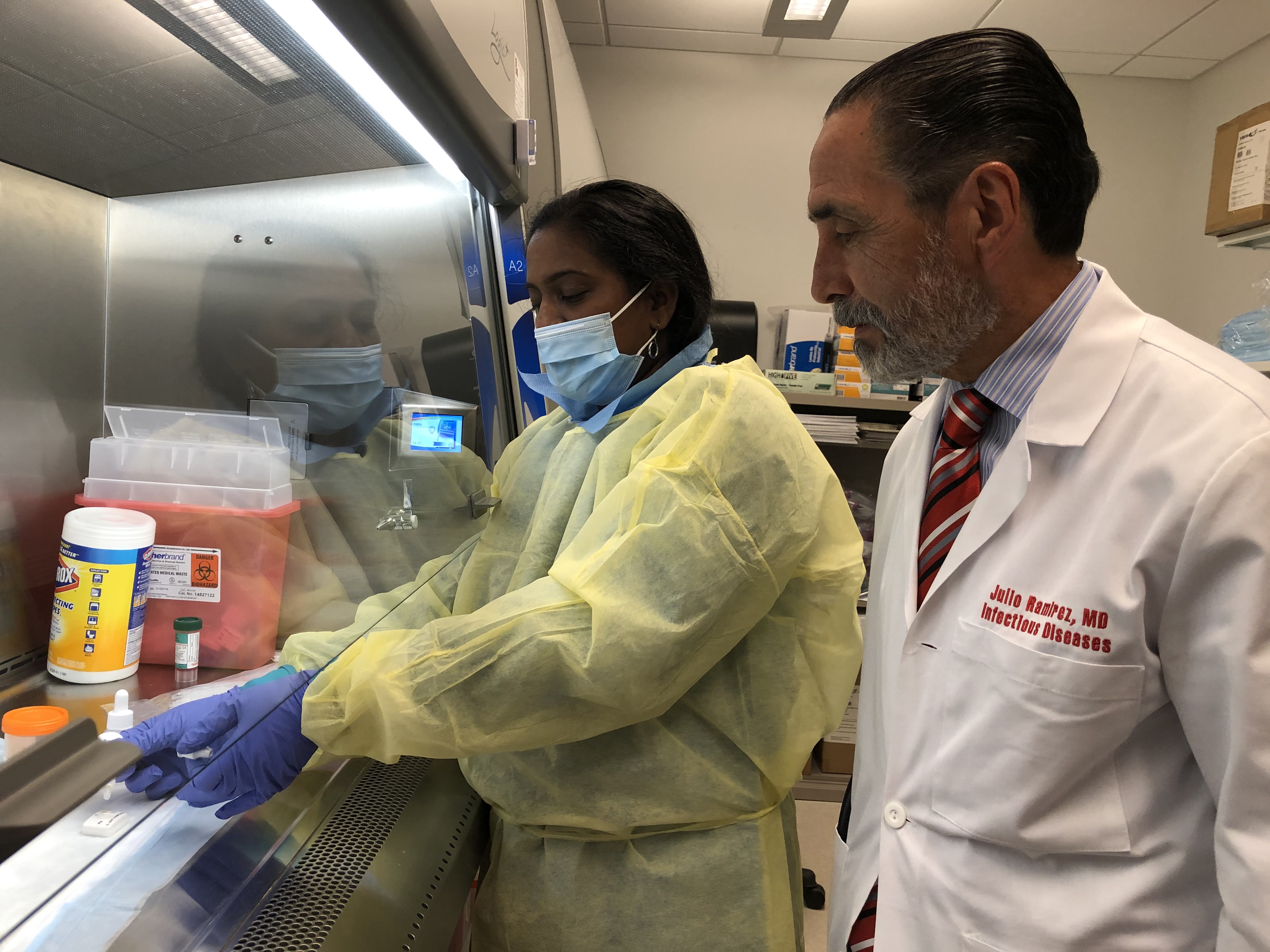 Julio Ramirez, M.D., right, in the UofL infectious diseases laboratory