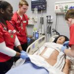 Undergraduate nursing students learn together in the simulation lab.