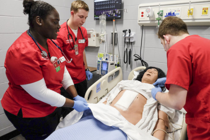 Undergraduate nursing students learn together in the simulation lab.