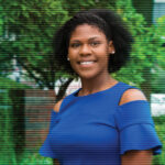 Keionna Bailey, standing in front of greenery