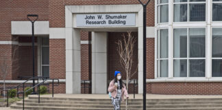 A masked student walks across campus in March, shortly after the COVID-19 pandemic outbreak.