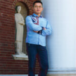 Donghang Zhang,a graduate of the University of Louisville, leaning against a pillar