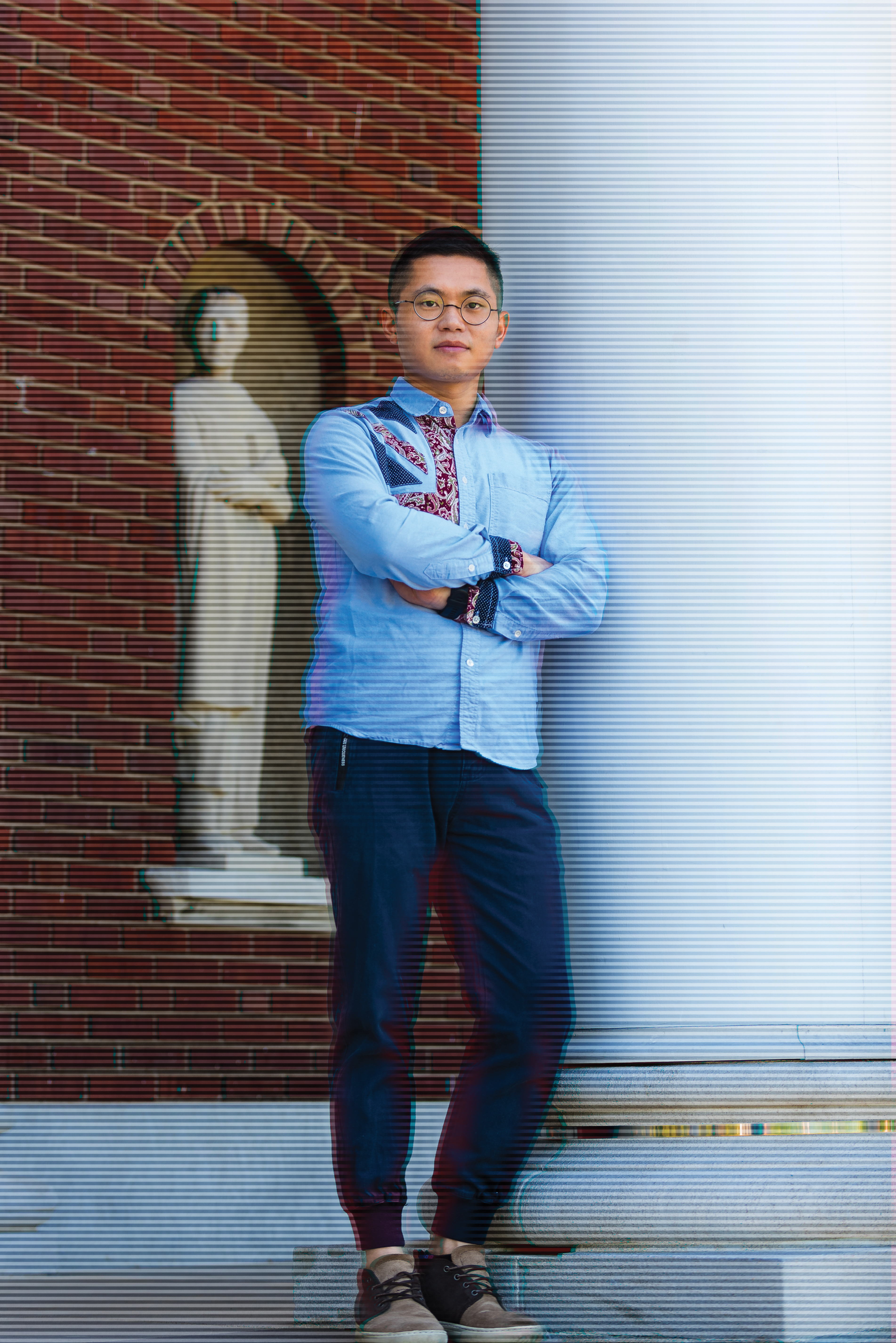 Donghang Zhang,a graduate of the University of Louisville, leaning against a pillar