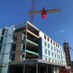 The topmost beam of a new student residence hall was set into place, marking a milestone toward the building’s completion.