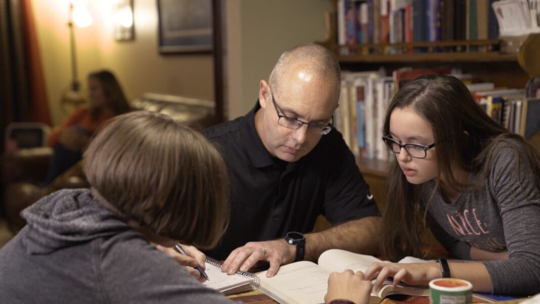 UofL online learning student David Beumer studying at home with family.