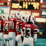 Kathryn Klope vanTonder stands alongside several teammates at a football game in the old Cardinal Stadium.