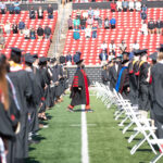 President Neeli Bendapudi walks past 2020 and 2021 graduates