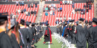 President Neeli Bendapudi walks past 2020 and 2021 graduates