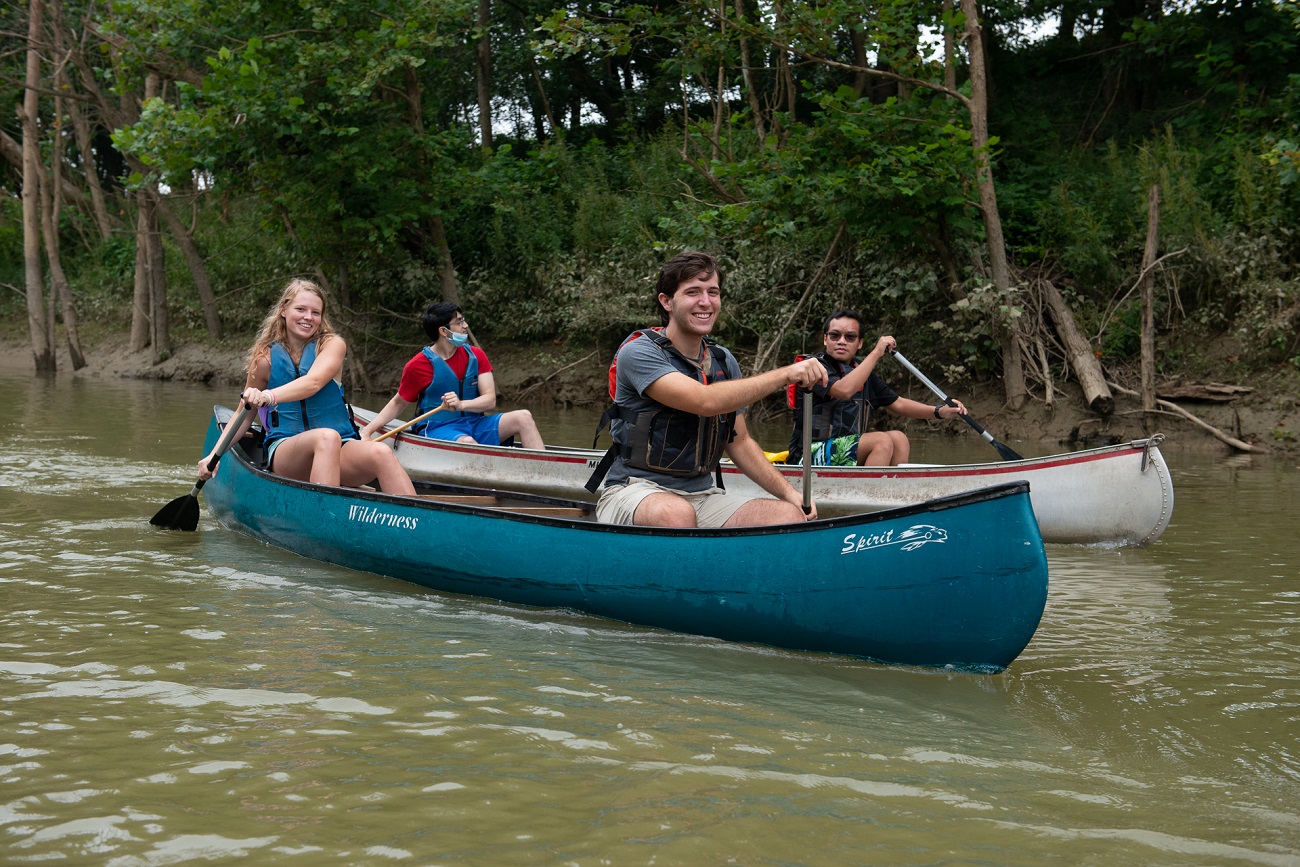 University of Louisville honors students Forest Clevenger (leading the blue canoe) Vinh Pham (leading the white canoe) paddle the Ohio River as part of a class that investigated how river towns can drive tourism and economic development. Photo courtesy John Nation.