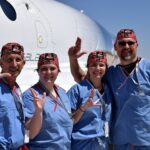 UofL astrosurgery team members George Pantalos, bioengineering student Sienna Shacklette, Tommy Roussel and bioengineering student Clara Jones in front of the Virgin Galactic VSS Unity SpaceShipTwo at Spaceport America in New Mexico.