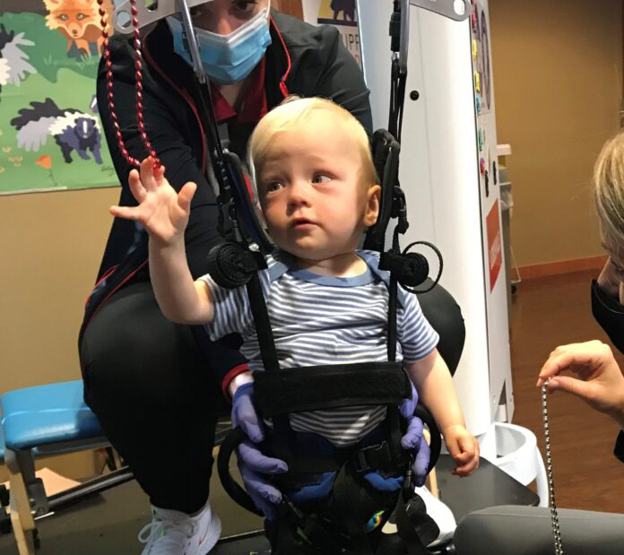 Luke Madson on a specially designed pediatric treadmill for therapy at the Kosair Charities Center for Pediatric Neurorecovery