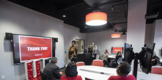 Cherie Dawson-Edwards speaks at a ceremony honoring lab renovation donor Sam Lord, far left at table, with President Neeli Bendapudi.