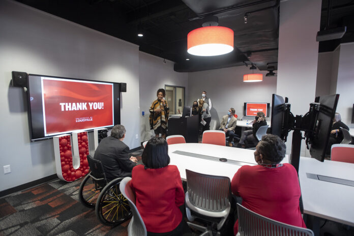 Cherie Dawson-Edwards speaks at a ceremony honoring lab renovation donor Sam Lord, far left at table, with President Neeli Bendapudi.