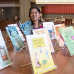 Hilaria Cruz with the children's books she wrote with the help of UofL students in her endangered languages course. The books are on display at Ekstrom Library as part of International Mother Language Day and the UNESCO's celebration of Indigenous Languages Decade.