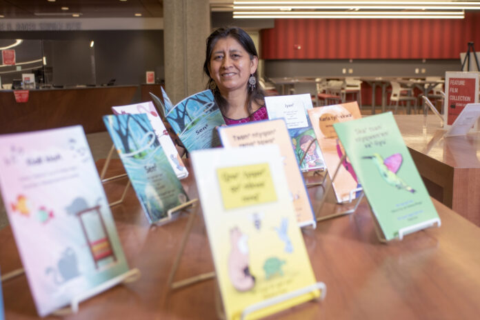 Hilaria Cruz with the children's books she wrote with the help of UofL students in her endangered languages course. The books are on display at Ekstrom Library as part of International Mother Language Day and the UNESCO's celebration of Indigenous Languages Decade.