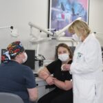 Two student officers of the American Association for Women Dentists talk with P. Gay Baughman.