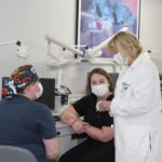 Two student officers of the American Association for Women Dentists talk with P. Gay Baughman.