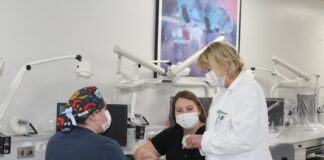 Two student officers of the American Association for Women Dentists talk with P. Gay Baughman.