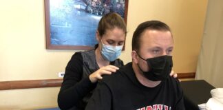 Keith Smith, UofL spinal cord research participant, with trainer Kristin Benton, working with the new tablet interface to control his Medtronic epidural stimulator