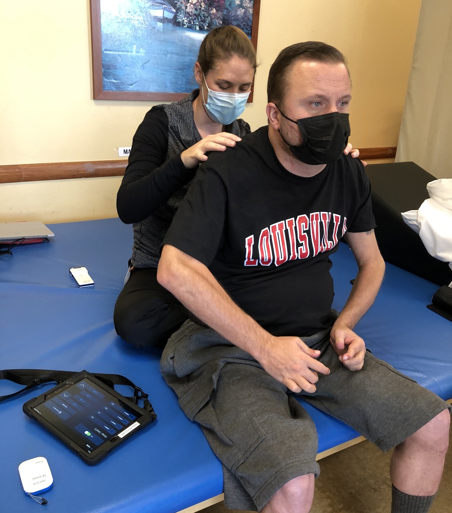 Keith Smith, UofL spinal cord research participant, with trainer Kristin Benton, working with the new tablet interface to control his Medtronic epidural stimulator