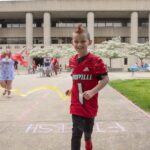 Seth Walsh, who received a Kentucky Derby Festival miniMartahon medal from med student David Means as part of the Medals4Mettle program.