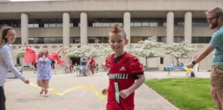 Seth Walsh, who received a Kentucky Derby Festival miniMartahon medal from med student David Means as part of the Medals4Mettle program.