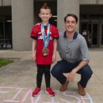 Seth Walsh received a Kentucky Derby Festival miniMartahon medal from med student David Means as part of the Medals4Mettle program.