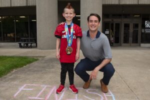 Seth Walsh, who is battling leukemia, received a Kentucky Derby Festival miniMartahon medal from med student David Means as part of Medals4Mettle