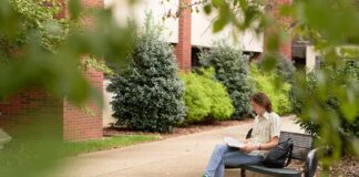 Student reading outside the College of Education and Human Development