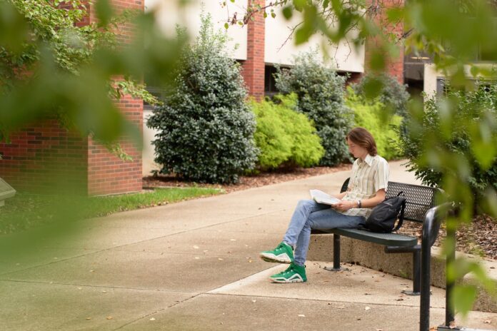 College of Education_small Student reading outside the College of Education and Human Development