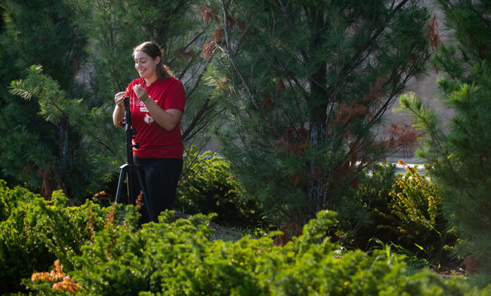 Maddy Cicha unfolds a tripod to set up a noise monitor.