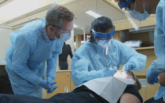 Wil Abshier, left, assistant professor of comprehensive dentistry at the University of Louisville School of Dentistry, is a recent graduate of UofL’s new Master of Science in Health Professions Education program.