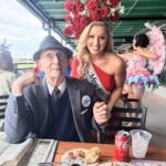 photo of older gentleman sitting at a table with a female pageant winner