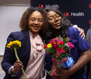 Orion Rushin, left, embraced Karen Udoh, right, who was recognized with a special sendoff for her role in the launch of the Future Healers Program