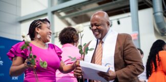 Candice Hardin, Louisville Teacher Residency (LTR) coach at JCPS, hands a rose to LTR graduate Donald Morehead at the graduation celebration on May 18 (photo courtesy JCPS)