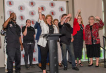 The University Club hospitality team and representatives from UofL toast the grand reopening of the University Club. -Photo by Ron Harrison
