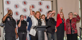 The University Club hospitality team and representatives from UofL toast the grand reopening of the University Club. -Photo by Ron Harrison