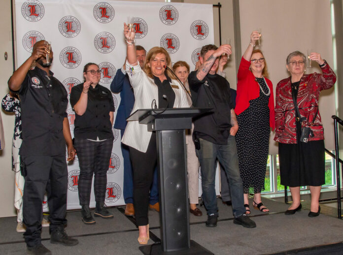 The University Club hospitality team and representatives from UofL toast the grand reopening of the University Club. -Photo by Ron Harrison