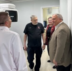 UofL School of Dentistry alumnus Bill Collins (center), UofL President Kim Schatzel   and Kentucky Senate President Robert Stivers, R-Manchester (right) talk with a provider at Red Bird Dental Clinic. 