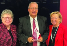 The University of Louisville Board of Trustees recognized John Smith (center) for his more than 36 years of service to the university. Smith, who recently retired as UofL's assistant director of intramural and recreational sports, served on UofL's Staff Senate (chair, 2018-2023) and as the staff representative on the Board of Trustees. Pictured with Smith are UofL President Kim Schatzel, left, and Board Chair Mary Nixon.