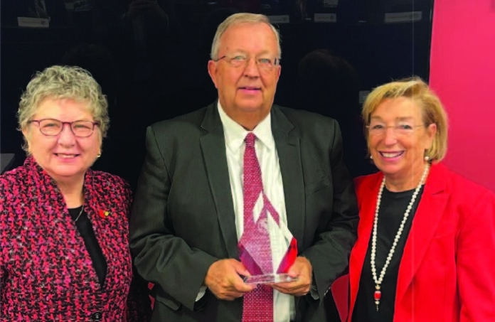 The University of Louisville Board of Trustees recognized John Smith (center) for his more than 36 years of service to the university. Smith, who recently retired as UofL's assistant director of intramural and recreational sports, served on UofL's Staff Senate (chair, 2018-2023) and as the staff representative on the Board of Trustees. Pictured with Smith are UofL President Kim Schatzel, left, and Board Chair Mary Nixon.
