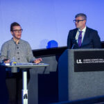 Two people speak at a podium