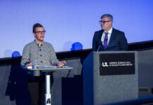 Two people speak at a podium