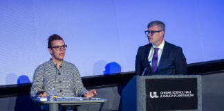 Two people speak at a podium